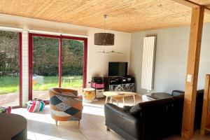 uma sala de estar com um sofá de couro e uma televisão em Maison 180m2, jardin clos, 2 terrasses, 5 mn Dinan em Vildé-Guingalan