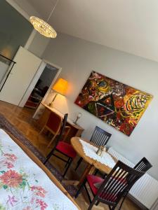 ein Zimmer mit einem Tisch und Stühlen sowie einem Gemälde an der Wand in der Unterkunft Villa Pazelt Top4 in Bad Vöslau