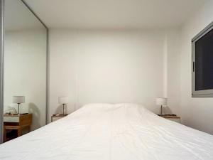 1 cama blanca en una habitación con 2 lámparas en Fk Alojamientos Liniers en Buenos Aires