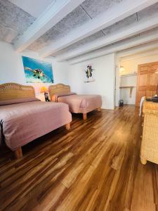 a bedroom with two beds and a wooden floor at Key Colony Beach Motel in Marathon