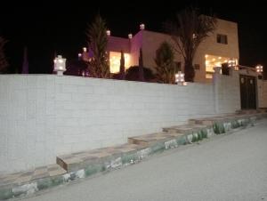 biała ceglana ściana ze schodami przed domem w obiekcie Bait al salam w mieście Um Qeis