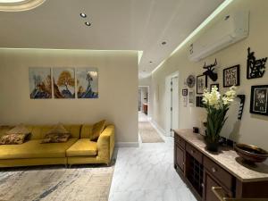 ein Wohnzimmer mit einem gelben Sofa und einem Tisch in der Unterkunft شقة فاخرة ٣ غرف وصالة ٣ in Riad