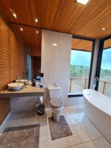 La salle de bains est pourvue d'une baignoire, d'un lavabo et de toilettes. dans l'établissement Castelinho Ibitipoca, à Lima Duarte