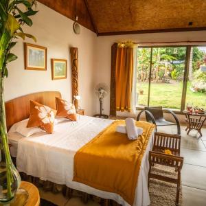 a bedroom with a bed and a large window at Hotel Chez Maria Goretti in Hanga Roa