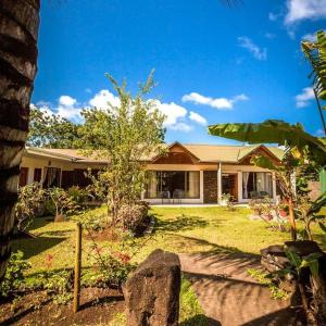 a house with a yard with trees and plants at Hotel Chez Maria Goretti in Hanga Roa