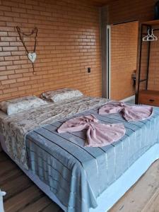 - un grand lit dans une chambre dotée d'un mur en briques dans l'établissement Castelinho Ibitipoca, à Lima Duarte