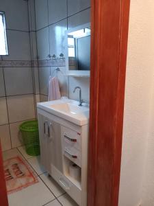 y baño con lavabo y espejo. en Apartamento das Azaléias térreo en Novo Hamburgo