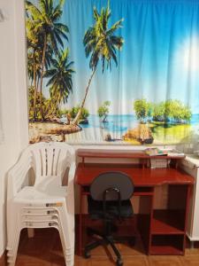 ein Büro mit einem Schreibtisch und einem Fenster mit Palmen in der Unterkunft Apartamento das Azaléias térreo in Novo Hamburgo