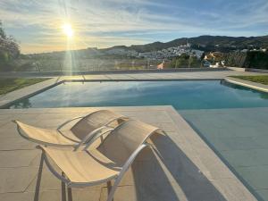 een witte stoel naast een zwembad bij apartamento piscina privada in Rincón de la Victoria