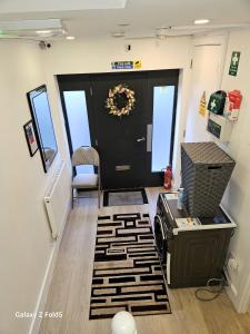 a hallway with a black door with a wreath on it at LONDON SLEEPHOUSE in London