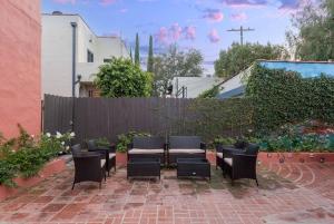 een patio met stoelen, een tafel en een hek bij Experience Luxury in a Spanish-Moroccan Escape in Los Angeles