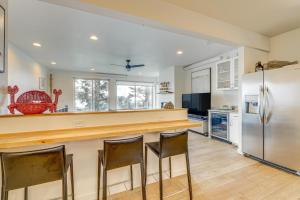 a kitchen with a counter and a refrigerator at Depoe Bay Townhome with Deck and Stunning Ocean Views! in Depoe Bay