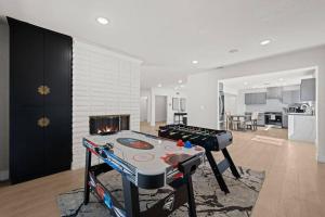 a living room with a ping pong table and a fireplace at Modern Luxe: 4BR Home with Private Jacuzzi in Los Angeles