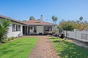 a house with a brick pathway in front of a yard at Modern Luxe: 4BR Home with Private Jacuzzi in Los Angeles