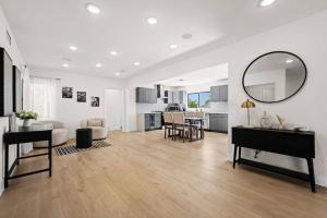 a white living room with a table and a mirror at Modern Luxe: 4BR Home with Private Jacuzzi in Los Angeles