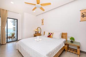 een slaapkamer met een bed en een plafondventilator bij ARIA- VŨNG TÀU - Căn hộ, villa nghỉ dưỡng cao cấp sát bãi biển riêng miễn phí in Vung Tau