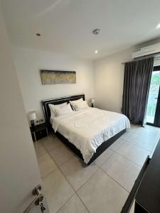 a bedroom with a large bed with white sheets at The Pine Court in Accra