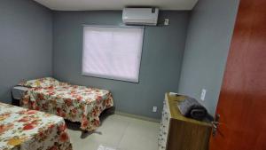 リオ・ベルデにあるDECORADO 23-E 2 qts com ar-condicionadoのベッド2台と窓が備わる小さな客室です。