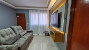 salon z kanapą i telewizorem z płaskim ekranem w obiekcie DECORADO 23-E 2 qts com ar-condicionado w mieście Rio Verde