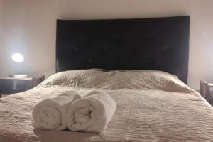 ein Bett mit zwei Handtüchern darüber in der Unterkunft Elegante residencia! in Ezeiza