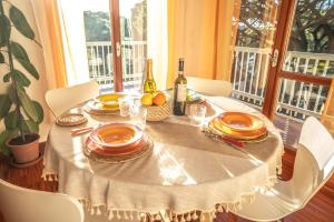 a table with plates and a bottle of wine at Attico panoramico, a pochi passi dal mare, due parcheggi interni inclusi in Milano Marittima +11 photos