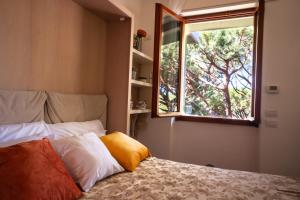 a bedroom with a bed and a window at Attico panoramico terrazzato centrale con parcheggio gratuto in Milano Marittima