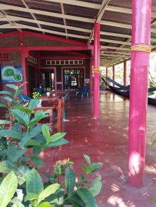 a pavilion with tables and a hammock in a building at El Güis hostel in Balgue
