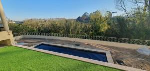 Azurara Guesthouse في Azurara: حمام سباحة على شرفة مع عشب أخضر