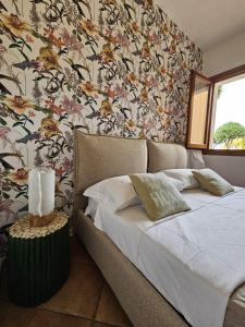 - une chambre avec un lit et un papier peint floral dans l'établissement Casa Elvira, à Porto Pollo