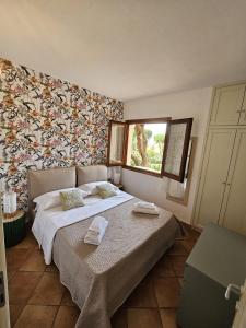 - une chambre avec un grand lit et des serviettes dans l'établissement Casa Elvira, à Porto Pollo