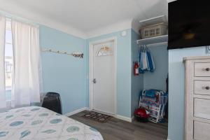 1 dormitorio con paredes azules, 1 cama y puerta en Quarter Deck 2 | Flagler Beach | N Ocean Shore Blvd, en Flagler Beach