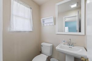 Un baño con inodoro, lavabo y espejo. en Quarter Deck 2 | Flagler Beach | N Ocean Shore Blvd, en Flagler Beach 31 fotos más