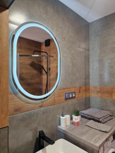 La salle de bains est pourvue d'un lavabo et d'un miroir. dans l'établissement Apartament K&H W Centrum, à Tarnów