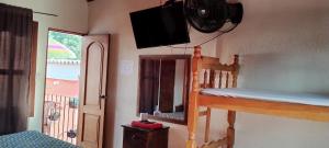 a bedroom with a bunk bed with a television on the wall at Hotel City of Dreams Antigua in Antigua Guatemala