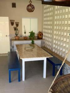 eine Küche mit einem weißen Tisch und 2 blauen Stühlen in der Unterkunft Casinha da Paz in Aracaju