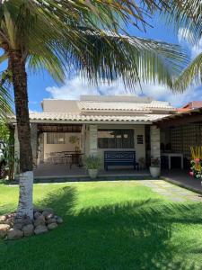 ein Haus mit einer Palme im Hof in der Unterkunft Casinha da Paz in Aracaju
