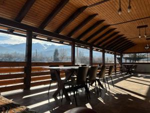 - une salle à manger avec une table, des chaises et des montagnes dans l'établissement La Văru, à Cârţişoara