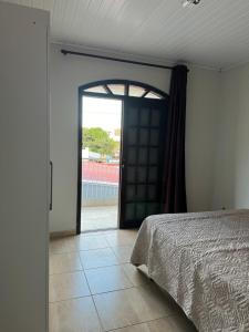 a bedroom with a bed and an open door at Cantinho do Aconchego in São Lourenço