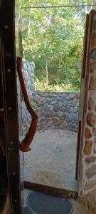 una porta aperta con vista su un muro di pietra di Huaca Huaca Hostel a Mocoa