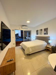 1 dormitorio con 1 cama, TV y mesa en Fk Alojamientos Liniers en Buenos Aires
