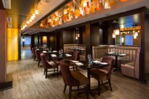 a restaurant with tables and chairs in a room at Mt Lady MacDonald Suite @ Grande Rockies in Canmore