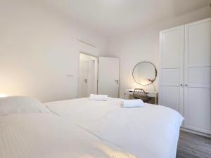 biała sypialnia z 2 łóżkami i lustrem w obiekcie Wings - Brand New - Presidential Garden - Free Parking w Bratysławie