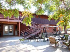 a building with a table and chairs in front of it at Mexican Hat Lodge in Mexican Hat