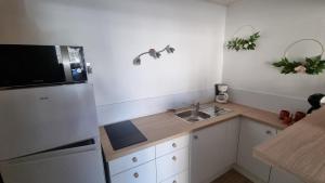 a small kitchen with a sink and a refrigerator at Gite Mérignac proche Aéroport in Mérignac