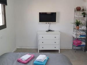 a bedroom with a bed and a tv and a dresser at בלב העיר in Netanya