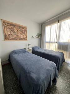 two beds in a hotel room with blue sheets at Cálido monoambiente en San Telmo in Buenos Aires