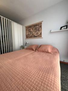 a bedroom with a bed with an orange comforter at Cálido monoambiente en San Telmo in Buenos Aires
