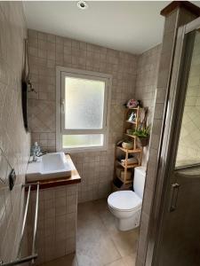 a bathroom with a toilet and a sink and a window at Casa en Laredo in Laredo