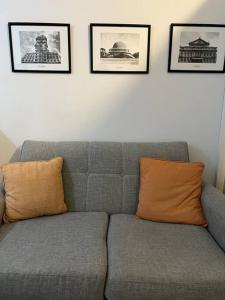 a gray couch with an orange pillow in a living room at Cálido monoambiente en San Telmo in Buenos Aires