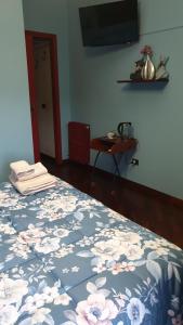 sypialnia z łóżkiem z niebieskim kocem i kwiatami w obiekcie A casa di Manu w mieście Isola del Liri
